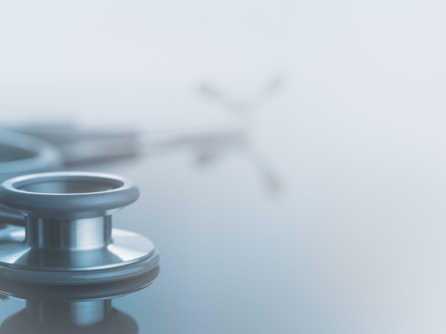 Medical background, Close up stethoscope on glass table with reflection and copy space, monotone, soft background.